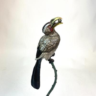 Sale Photo Thumbnail #96: Made out of bronze and polychrome.Hornbill depicted with an egg in its beak, its talons gripping a curved branch; on black round stepped plinth base.  
Measurements:
Bird is 14.5" height, 6.5" diameter for base, total height is 28" height
Valued @ $2500.0