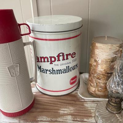 Campfire and oil lamps with thermos and candle