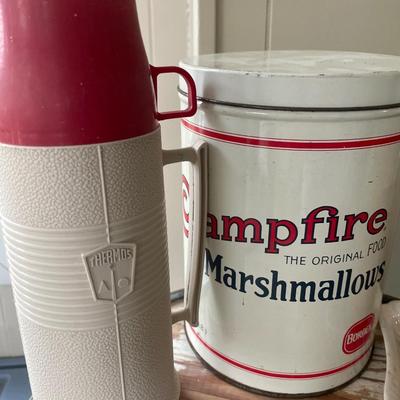 Campfire and oil lamps with thermos and candle