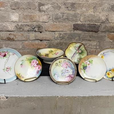 Sale Photo Thumbnail #299: Two handled footed bonbon with roses, single handled tidbit, two 7 3/4” plates and three beautiful 6 1/2” plates, all hand panted