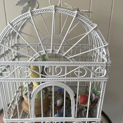 Metal bird cage with ceramic bird figurines
