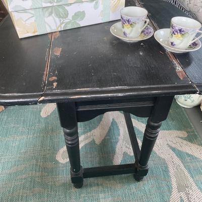 Black painted table with drop leaf sides and purple tea set