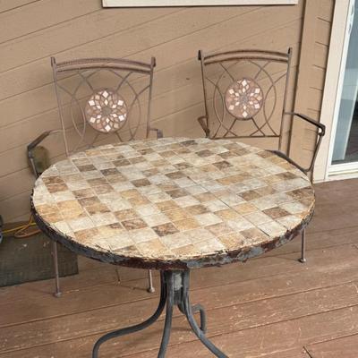 Sale Photo Thumbnail #45: Add charm to your patio or porch with this decorative 3-piece bistro set. The set includes two matching metal chairs with beautiful mosaic-style medallion backs and a round, tile-top table.

? The table features neutral stone-look tiles in a checkerboard 