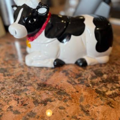 Sale Photo Thumbnail #74: Adorable black and white ceramic cow with a red scarf—perfect as a cookie jar, treat container, or charming countertop décor. A fun farmhouse-style accent.
