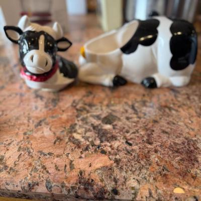 Sale Photo Thumbnail #77: Adorable black and white ceramic cow with a red scarf—perfect as a cookie jar, treat container, or charming countertop décor. A fun farmhouse-style accent.