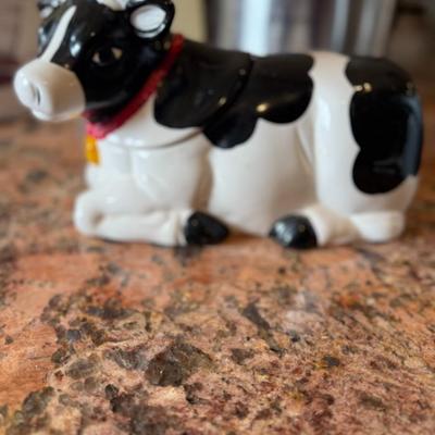 Sale Photo Thumbnail #76: Adorable black and white ceramic cow with a red scarf—perfect as a cookie jar, treat container, or charming countertop décor. A fun farmhouse-style accent.