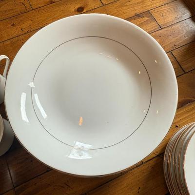 Sale Photo Thumbnail #105: Timeless and refined, this 1995 “Classic Elegance” fine china set by The Cellar includes dinner plates, salad plates, bowls, cups, a teapot, creamer, sugar bowl, and serving pieces. White with a thin gold rim, perfect for formal dining or holiday gath