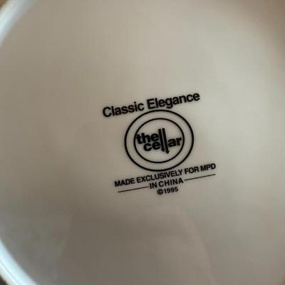 Sale Photo Thumbnail #95: Timeless and refined, this 1995 “Classic Elegance” fine china set by The Cellar includes dinner plates, salad plates, bowls, cups, a teapot, creamer, sugar bowl, and serving pieces. White with a thin gold rim, perfect for formal dining or holiday gath