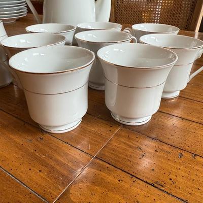 Sale Photo Thumbnail #107: Timeless and refined, this 1995 “Classic Elegance” fine china set by The Cellar includes dinner plates, salad plates, bowls, cups, a teapot, creamer, sugar bowl, and serving pieces. White with a thin gold rim, perfect for formal dining or holiday gath