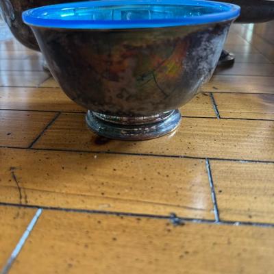 Sale Photo Thumbnail #170: Striking set of three mid-century silver-toned footed bowls with vibrant blue glass interiors. Unique accent bowls or serving pieces.