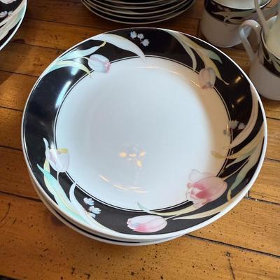 Sale Photo Thumbnail #177: Elegant porcelain dinnerware with black border and soft pink tulip pattern. Service for 4–6 includes plates, bowls, mugs, and serving pieces. Marked "Westbrook Collections - Mirage - Japan".