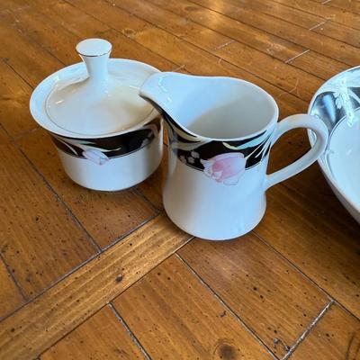 Sale Photo Thumbnail #190: Elegant porcelain dinnerware with black border and soft pink tulip pattern. Service for 4–6 includes plates, bowls, mugs, and serving pieces. Marked "Westbrook Collections - Mirage - Japan".