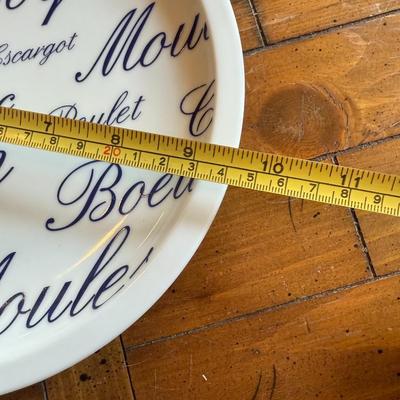 Sale Photo Thumbnail #196: Classic white and blue ceramic plates with French words and illustrations for meats and seafood (Poulet, Boeuf, Poisson, etc.). Bistro-style charm for kitchen or display.