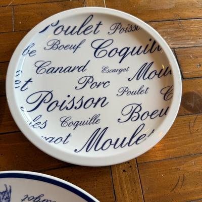 Sale Photo Thumbnail #194: Classic white and blue ceramic plates with French words and illustrations for meats and seafood (Poulet, Boeuf, Poisson, etc.). Bistro-style charm for kitchen or display.