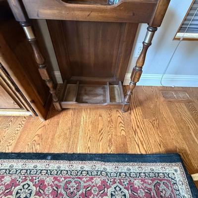 Sale Photo Thumbnail #222: Solid wood hall tree with upper hooks, central mirror, and umbrella stand base. Perfect for entryway organization.