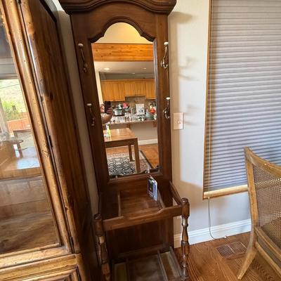 Sale Photo Thumbnail #218: Solid wood hall tree with upper hooks, central mirror, and umbrella stand base. Perfect for entryway organization.