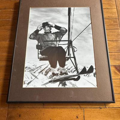 Sale Photo Thumbnail #239: Vintage-style black and white photo of a woman on a ski lift, framed with brown matte.