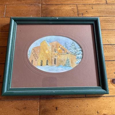 Sale Photo Thumbnail #248: Small framed print featuring a cozy house in the snow. Green frame with oval-cut brown matte.