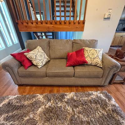 Sale Photo Thumbnail #379: Neutral-toned sofa with rolled arms and nailhead trim, includes four accent pillows. Excellent condition.
