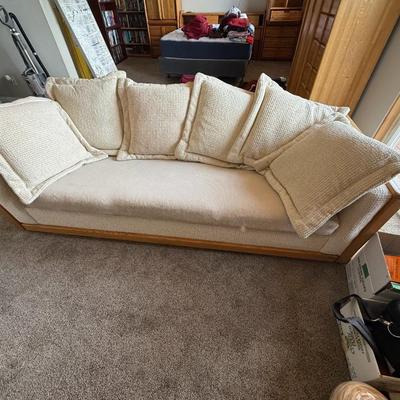 Sale Photo Thumbnail #415: Neutral-toned 3-seater couch with firm cushioning and a sturdy exposed wood frame. Comes with five oversized matching pillows. Classic yet comfortable, this piece complements modern or traditional interiors.