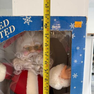 Sale Photo Thumbnail #435: Vintage lighted and animated Christmas Santa figure by Merrymakers. Holds a glowing candle and moves gently when plugged in. Original packaging with wear.