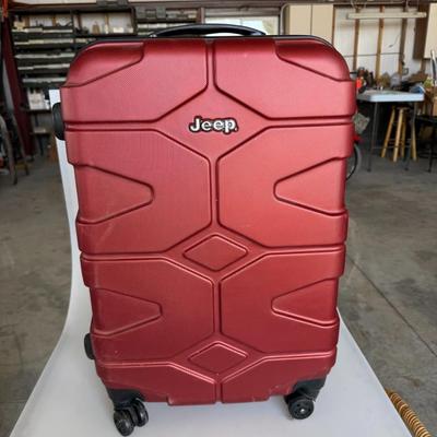Sale Photo Thumbnail #1: Durable red hard-shell carry-on suitcase by Jeep with smooth-rolling wheels and telescoping handle. Great for travel or short trips.