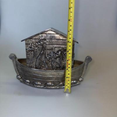 Sale Photo Thumbnail #72: Metal coin bank in the shape of Noah’s Ark with engraved animal details.