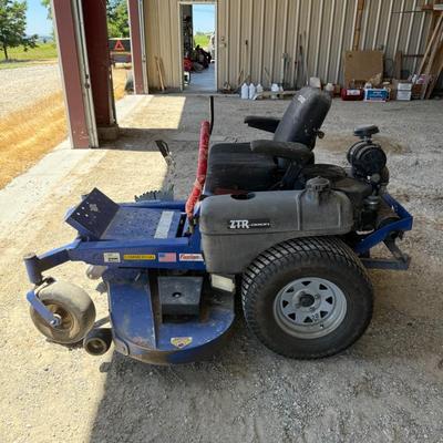 Sale Photo Thumbnail #151: This heavy-duty Dixon Grizzly mower features a commercial-grade zero-turn radius design, making it ideal for large property maintenance or landscaping use. It has dual lever steering, a wide cutting deck, and a comfortable padded seat. The controls are ea