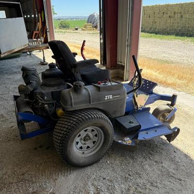 Sale Photo Thumbnail #149: This heavy-duty Dixon Grizzly mower features a commercial-grade zero-turn radius design, making it ideal for large property maintenance or landscaping use. It has dual lever steering, a wide cutting deck, and a comfortable padded seat. The controls are ea