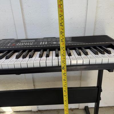 Sale Photo Thumbnail #197: Beginner-friendly keyboard with labeled keys, built-in rhythms, and stand. Fully functional with adapter included.