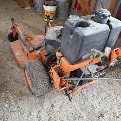 Sale Photo Thumbnail #231: Heavy-duty SCAG commercial mower with Kawasaki engine and 52" deck. Shows signs of use but is structurally solid. Ideal for landscapers or property owners needing tough mowing power.