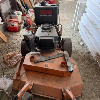 Sale Photo Thumbnail #228: Heavy-duty SCAG commercial mower with Kawasaki engine and 52" deck. Shows signs of use but is structurally solid. Ideal for landscapers or property owners needing tough mowing power.