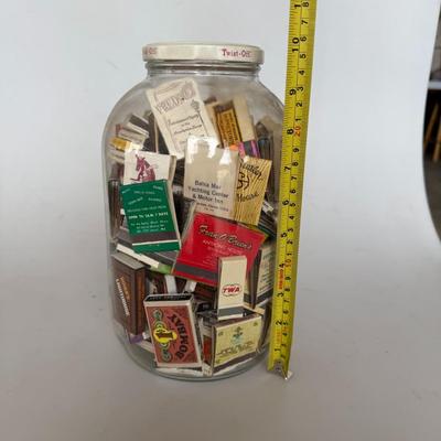 Sale Photo Thumbnail #241: Large glass jar filled with vintage matchbooks from various restaurants, hotels, and businesses — great for collectors or décor.