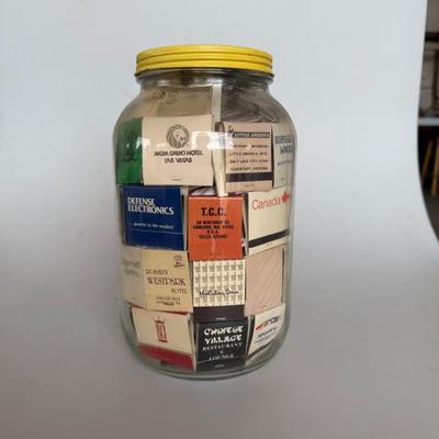 Sale Photo Thumbnail #242: Large glass jar filled with vintage matchbooks from various restaurants, hotels, and businesses — great for collectors or décor.