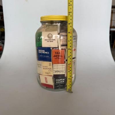 Sale Photo Thumbnail #243: Large glass jar filled with vintage matchbooks from various restaurants, hotels, and businesses — great for collectors or décor.