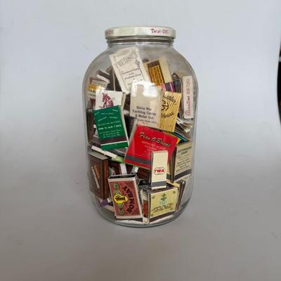 Sale Photo Thumbnail #240: Large glass jar filled with vintage matchbooks from various restaurants, hotels, and businesses — great for collectors or décor.