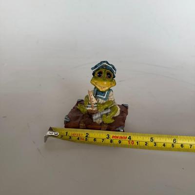 Sale Photo Thumbnail #288: Adorable sailor frog figurine holding a tiny boat. Great for whimsical collectors or nautical decor.