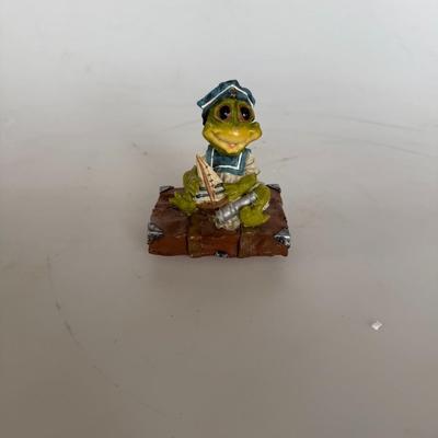 Sale Photo Thumbnail #285: Adorable sailor frog figurine holding a tiny boat. Great for whimsical collectors or nautical decor.