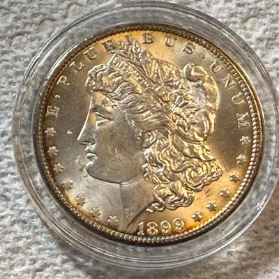 1899-O UNCIRCULATED CONDITION MORGAN SILVER DOLLAR AS PICTURED. (COIN #1832).