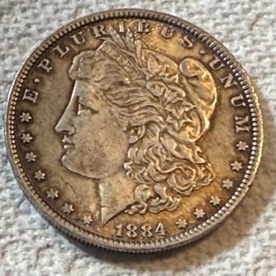 1884-O UNCIRCULATED TONED MORGAN SILVER DOLLAR AS PICTURED. (COIN #7195).