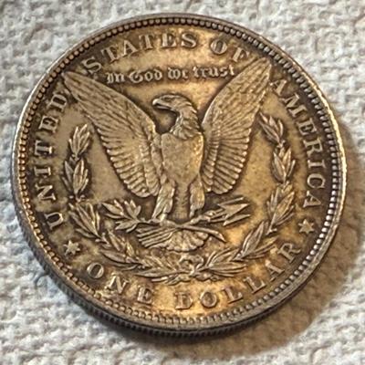 1884-O UNCIRCULATED TONED MORGAN SILVER DOLLAR AS PICTURED. (COIN #7195).