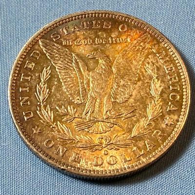1884-O UNCIRCULATED TONED MORGAN SILVER DOLLAR AS PICTURED. (COIN #7166).