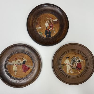 Sale Photo Thumbnail #506: Set of 3 plates showing traditional Basque costumed dancers and villagers.  Round wooden plates framing painted, embossed leather works of art. Plates are approx. 9.5" across.  Very good condition.