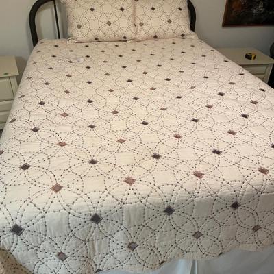 Queen mattress with black headboard and quilt comforter
