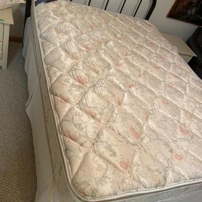 Queen mattress with black headboard and quilt comforter