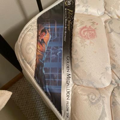 Queen mattress with black headboard and quilt comforter