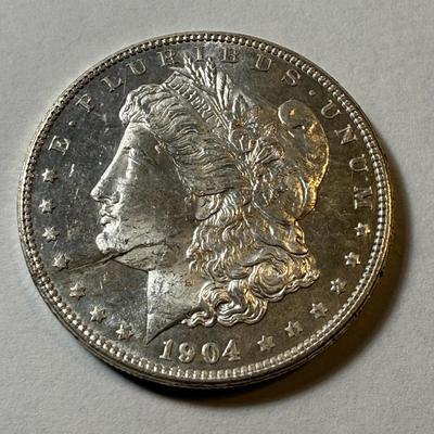 1904-O LAMINATION PEEL UNCIRCULATED CONDITION MORGAN SILVER DOLLAR AS PICTURED. (COIN #493).