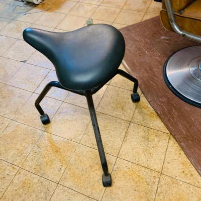 LOT 86: Mid - Century Adjustable Barber’s Chair with Barber Capes and a Three Leg Roll About Stool