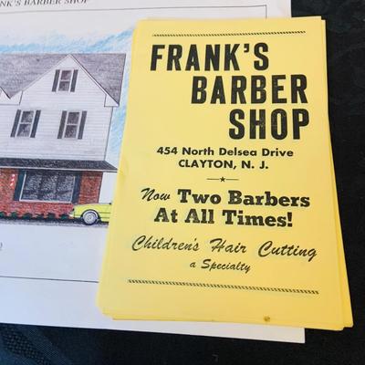 LOT 91: Barber Shop Memorabilia a Framed Etching, Cast Iron Haircut Plaque, Wooden Barber Poll, Books and Mor