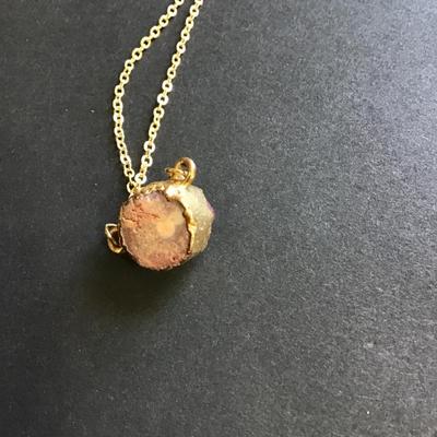 Gold toned necklace with purple crystal